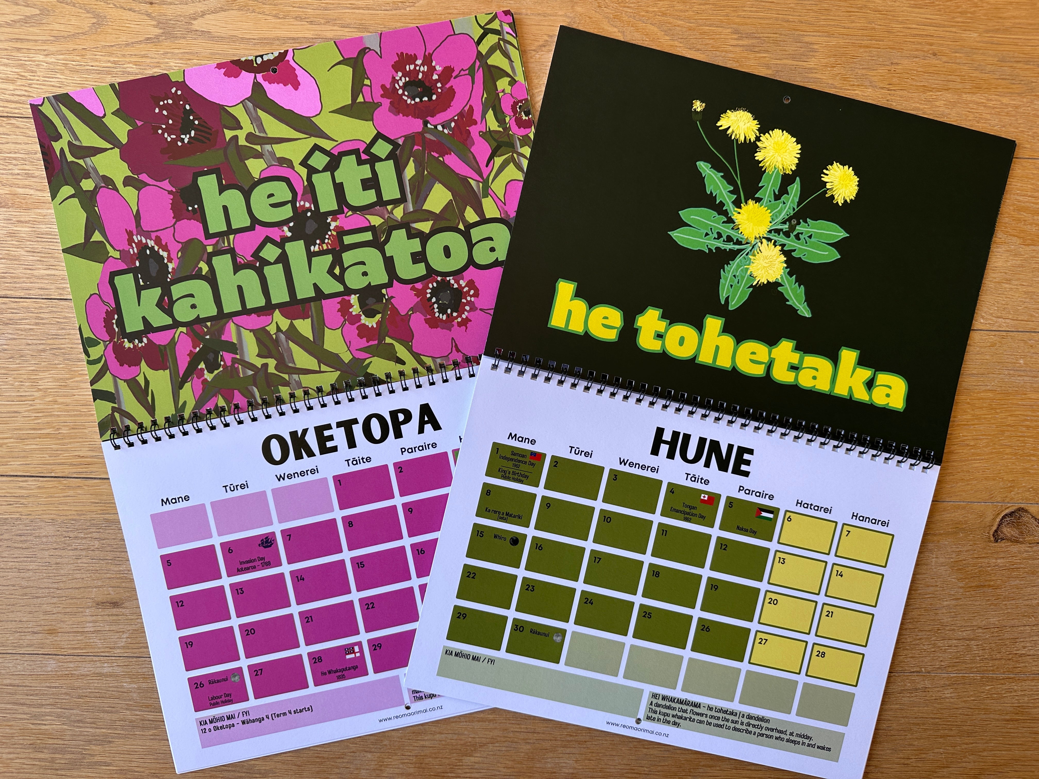 Two calendars with floral designs and text on a wooden surface